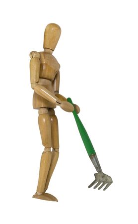 Raking in the garden shown by a wooden model holding a rakeの写真素材