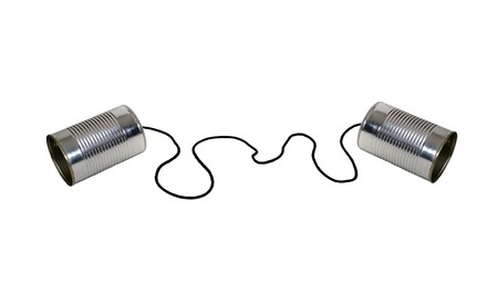 Retro communication shown by two tin cans on a string for a childs version of a telephoneの写真素材