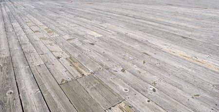 Wooden worn board that make up the pier stretching out the the horizon 