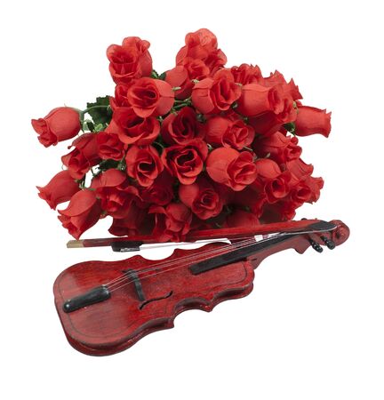 A classical gathering of long-stem red roses with a wooden violin の写真素材