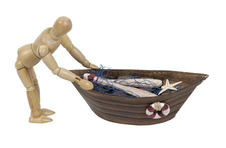 Wooden model representing a person pushing out a row boat with nets の写真素材