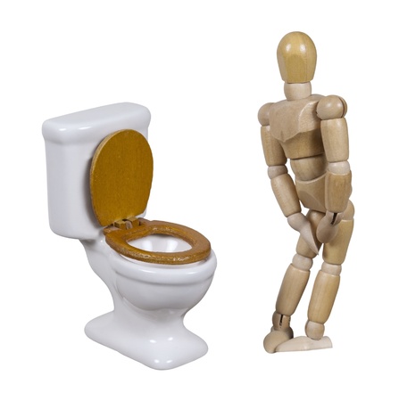 Model in need to relieve himself next to a porcelain toilet with wooden seat - path includedの写真素材