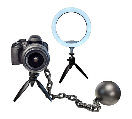 A camera tripod stand holding a camera with a beauty light and ball and chain