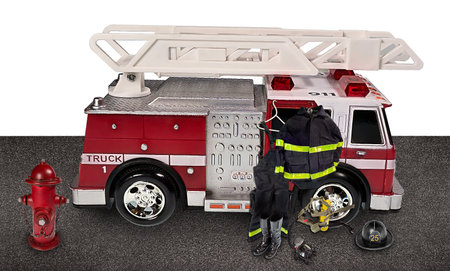 Fireman's outfit hanging off of a firetruck with a fire hydrant nearby