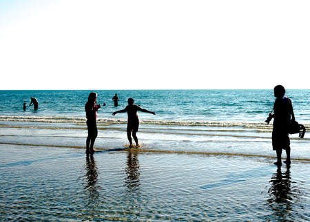 Beach in summer with people on the beach with  people in silhouette