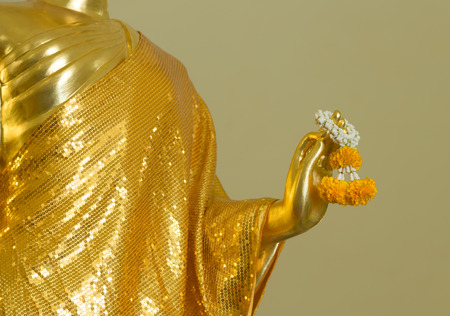 Buddha statue hold marigold garland closeupの写真素材