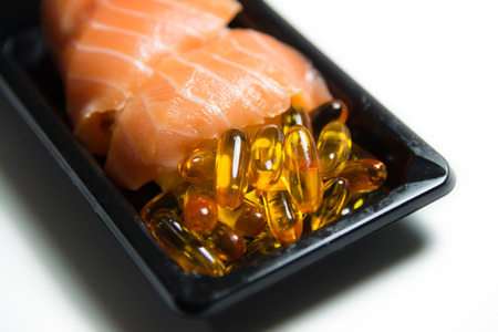 Salmon sushi served with fish oil capsules closeup isolated on white background focused ib fish oil pillsの写真素材