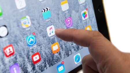 Bangkok, Thailand - July 2, 2015 : Human finger touch on screen Apple Music App on iOS 8.4 device  focused isolated on white backgroundのeditorial素材