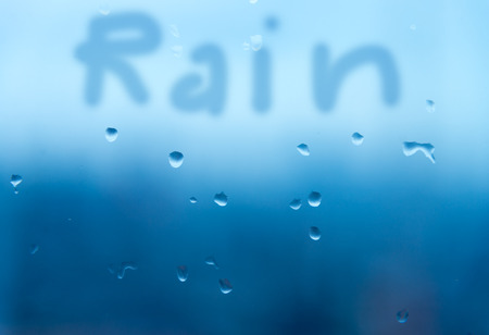 Mirror with rain drop background in blue tone with hand writing 'Rain'