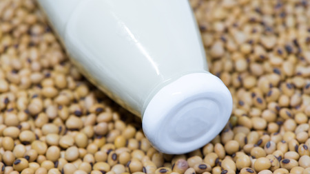 Soy milk  lied on soybean closeup on lidの写真素材