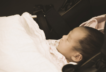 Asian Thai female baby sleeping on trollerの写真素材