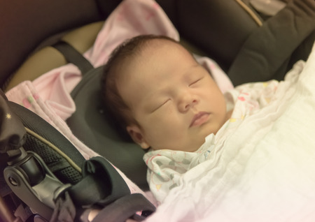 Asian Thai female baby sleeping on troller の写真素材