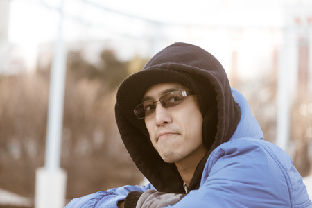 Asian male in hood wear sunglasses and  smile in the day of winter outdoors の写真素材