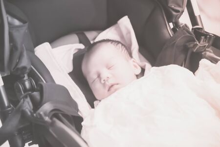 Asian Thai baby sleeping on stroller  closeup in pastel toneの写真素材