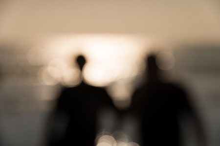 Defocused silhouette of people around the beach with sunlight and reflection in the afternoon abstract backgroundの写真素材