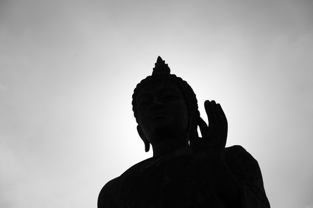 Buddha statue with dark silhouette with white  sunlightの写真素材