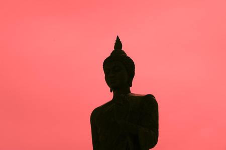 Buddha statue sculpture  silhouette on red background on sunset timeの写真素材