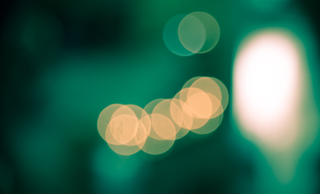 Defocused of blur bokeh in green  and orange split-tone abstract background of city lifeの写真素材