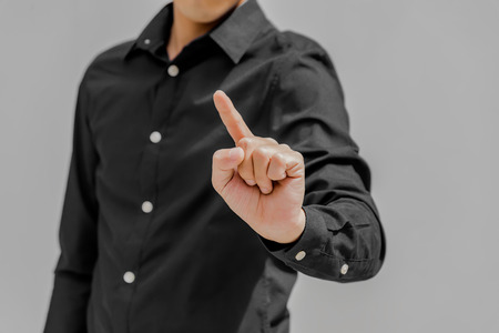 Business man  in black point  something with finger background. You can add anything at the finger with copy spaceの写真素材