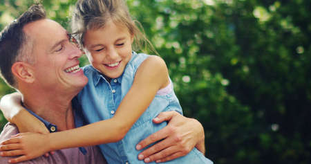 Everydays a fairytale when your daughter is a princess. Shot of an affectionate little girl spending quality time with her father outdoors.の写真素材