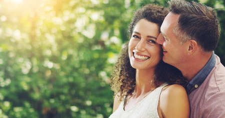 Hes the reason behind my smile. Shot of a happy and affectionate mature couple spending quality time together outdoors.の写真素材