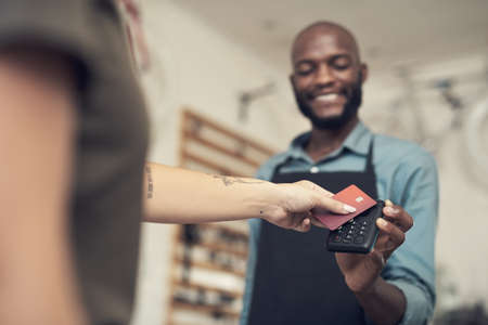 We really appreciate your support. Shot of a handsome young man standing in his bicycle shop and assisting a customer with her purchase.の写真素材
