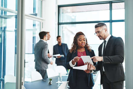 Getting some pre-presentation advice. Cropped shot of two corporate businesspeople talking before their meeting in the boardroom.の写真素材
