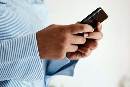 Never underestimate the power to connect. Cropped sot of an unrecognisable businesswoman using a smartphone.の写真素材