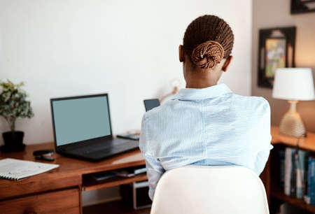 Wherever you are, work it out. Rearview shot of a young businesswoman using a smartphone while...