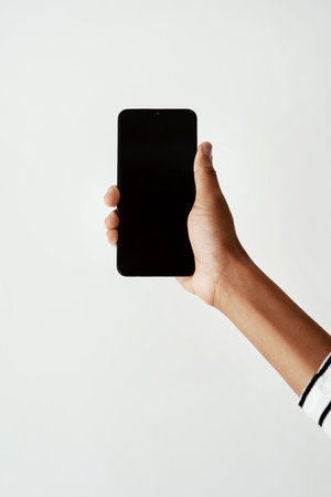 Lets make this go viral. Cropped shot of a woman using a smartphone against a white studio background.の写真素材