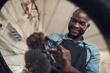 This bike really needed a new part. Low angle shot of a handsome young man standing alone in his...