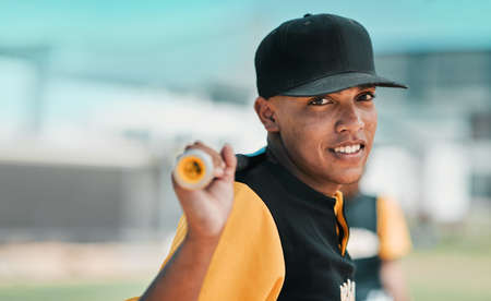 Baseball is without a doubt my favourite sport. Shot of a young baseball player holding a baseball bat while posing outside on the pitch.の写真素材