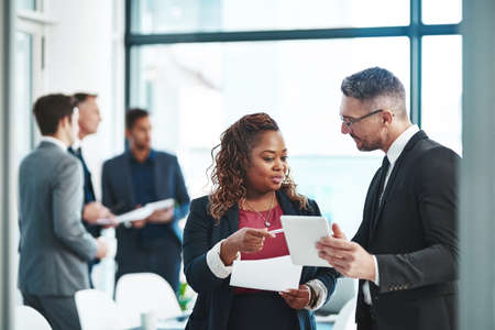 Can I get a copy of this please. Cropped shot of two corporate businesspeople talking before their...
