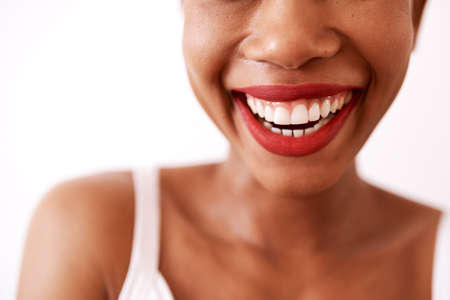 Red lipstick is such a confidence booster. Studio shot of an unrecognizable woman wearing red lipstick against a white background.の写真素材