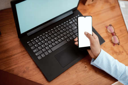 Completing business tasks with the power of technology. Cropped shot of a businesswoman using a...