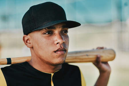 You can accomplish anything if you work hard enough. Shot of a young baseball player holding a baseball bat while posing outside on the pitch.の写真素材