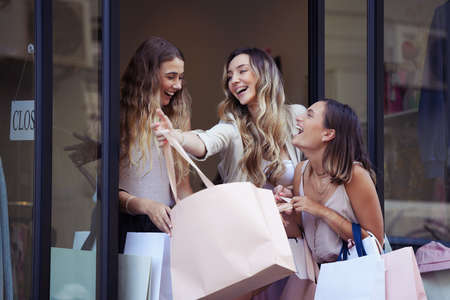 I love spending the day with my besties. Shot of a group of female friends having fun after shopping together.の写真素材