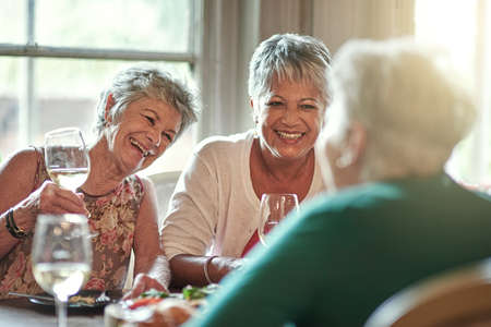 Spend your golden years with friends. Cropped shot of a group of senior female friends enjoying a lunch date.の写真素材