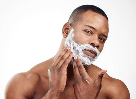 Shaving can give you a whole new look. Studio portrait of a handsome young man applying shaving...