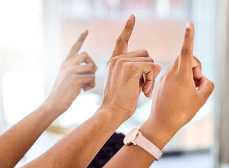 Being successful requires curiosity. Cropped shot of a group of people raising their hands during a presentation.の写真素材