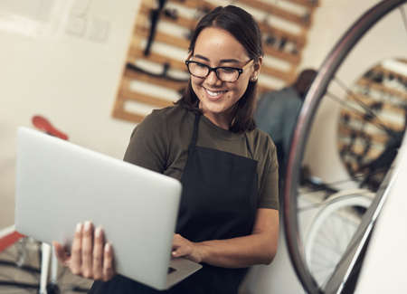 Emails are how I stay in touch with clients. Shot of an attractive young woman standing alone in her...