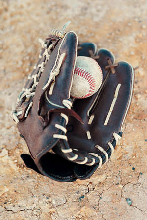 No game is over until the final out is made. Shot of a baseball mitt and ball lying on the pitch...