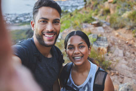 Youre my favourite person to hike with. Shot of a young couple taking photos while out on a hike in a mountain range outside.の写真素材