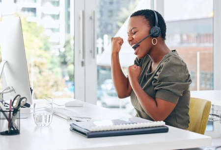 A good sale puts me in a good mood. Shot of a businesswoman looking cheerful while working in a call centre.の写真素材