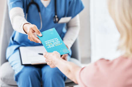 The best way to fight this virus is to educate yourself. Shot of a female nurse giving her patient a Covid-19 information pamphlet.の写真素材
