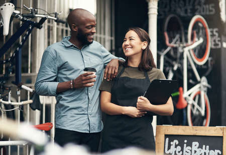 You have everything under control here, huh. Shot of two young business owners standing outside their bicycle shop during the day.の写真素材