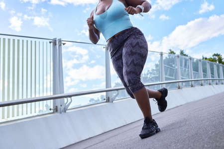 Life only happens when youre moving forward. Cropped shot of a woman running against an urban background.の写真素材