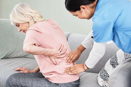 Lets find out whats causing your pain. Shot of a female nurse massaging her patients back.