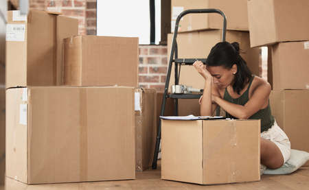 To some moving house is just another habit. Shot of a young woman having a stressful day during...