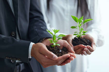 Preserving nature to help it flourish. Shot of two colleagues holding plants.の写真素材